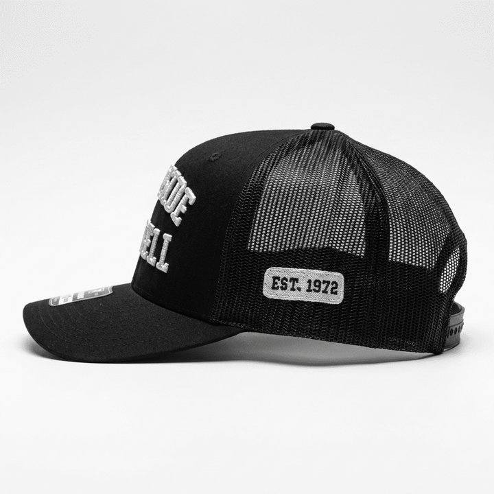 Side view of the Westside Barbell EST. 1972 black trucker snapback showing the EST. 1972 side patch and mesh back panel