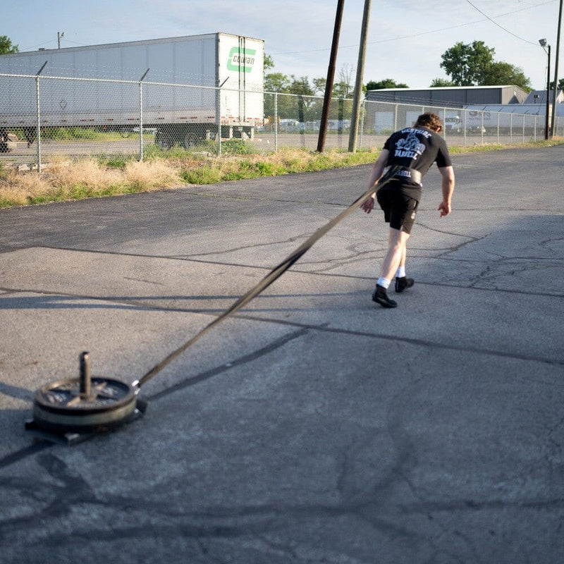 Athlete executing a sled pull for strength and conditioning at Westside Barbell.
