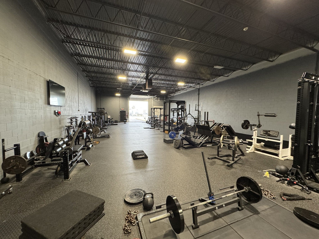 Westside Barbell athlete gym Gym interior with various exercise equipment on a concrete floor.