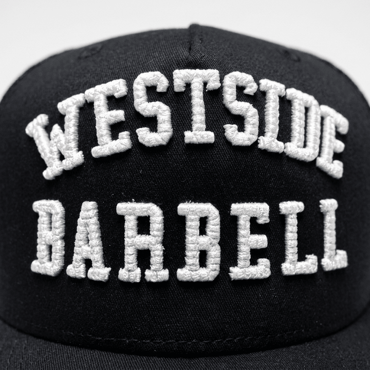 Close-up of the raised white WESTSIDE BARBELL embroidery on the black EST. 1972 snapback