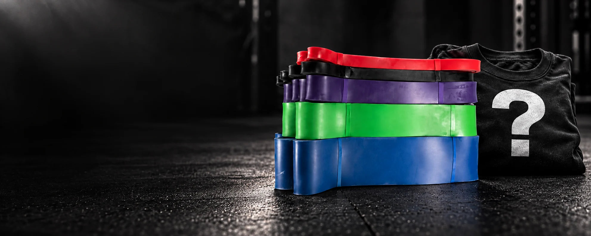Resistance bands beside mystery apparel in a dark gym